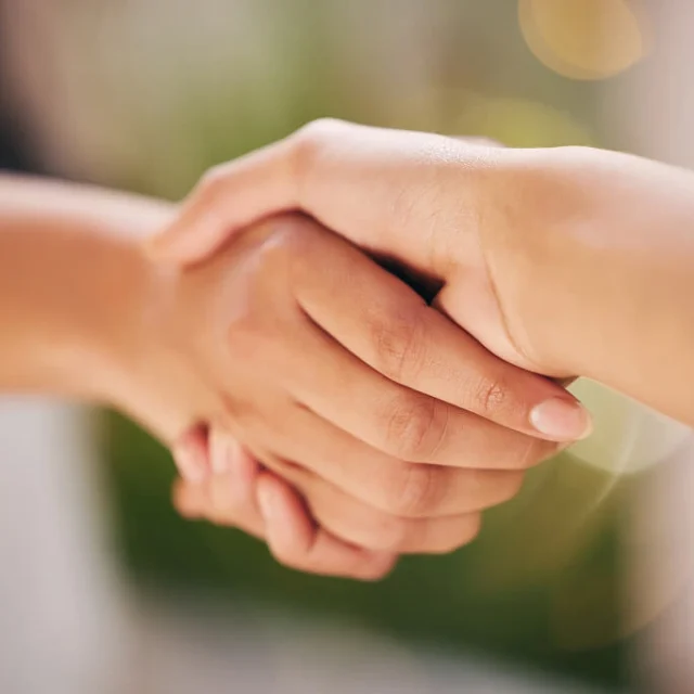 Two people shaking hands over a franchise agreement
